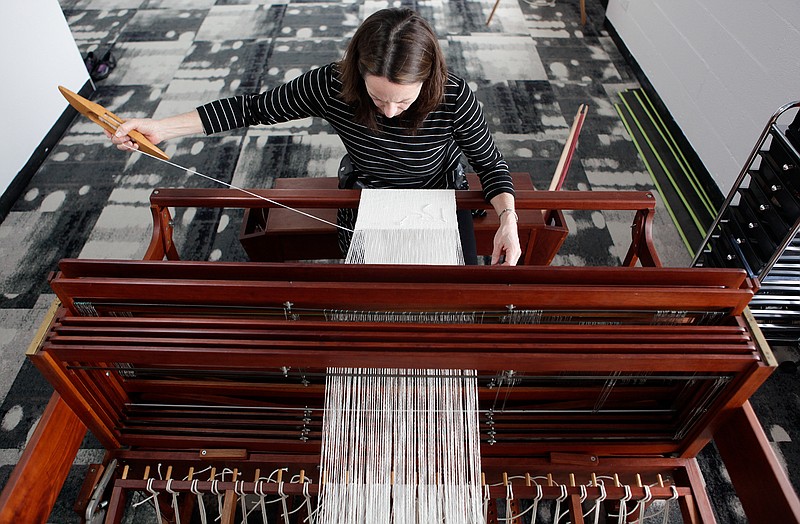 Kim Gavin weaves a tea towel at her floor loom in her studio at the Chattanooga Workspace. Gavin says weaving is therapeutic for her. 