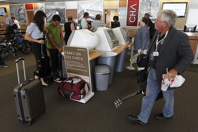  Bill Andrew, right, departs the ticketing counter at the Chattanooga Airport in this file photograph from June. 