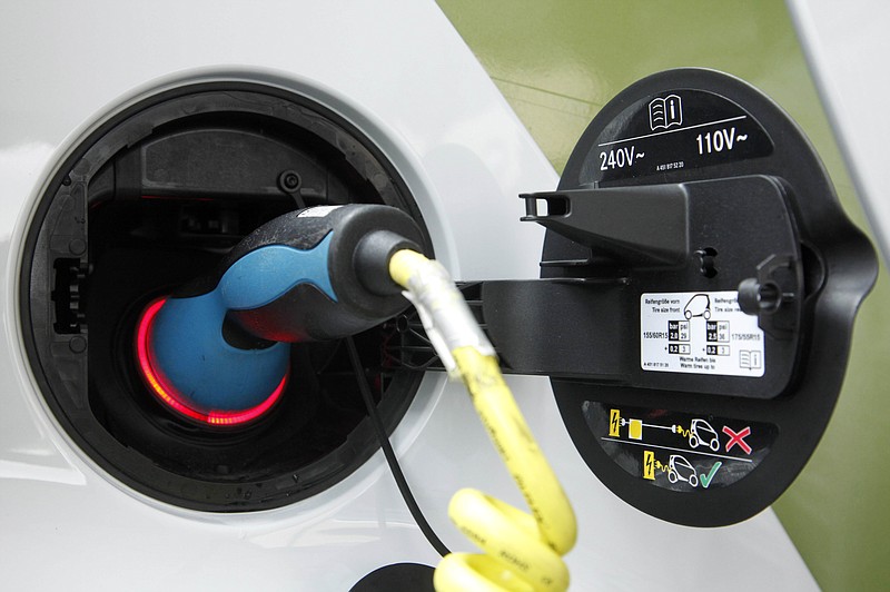 An electric plug charges a Smart Car electric drive vehicle.