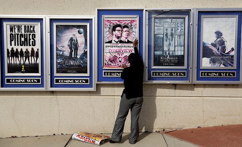 
              A poster for the movie "The Interview" is taken down by a worker after being pulled from a display case at a Carmike Cinemas movie theater, Wednesday, Dec. 17, 2014, in Atlanta. Georgia-based Carmike Cinemas has decided to cancel its planned showings of "The Interview" in the wake of threats against theatergoers by the Sony hackers. (AP Photo/David Goldman)
            
