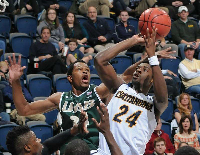 Chattanooga's Casey Jone (24) draws a crowd of University of Alabama at Birmingham players including defender William Lee (34) as he shoots a jump shot on the way to a 21-point lead at the half Monday at McKenzie Arena.