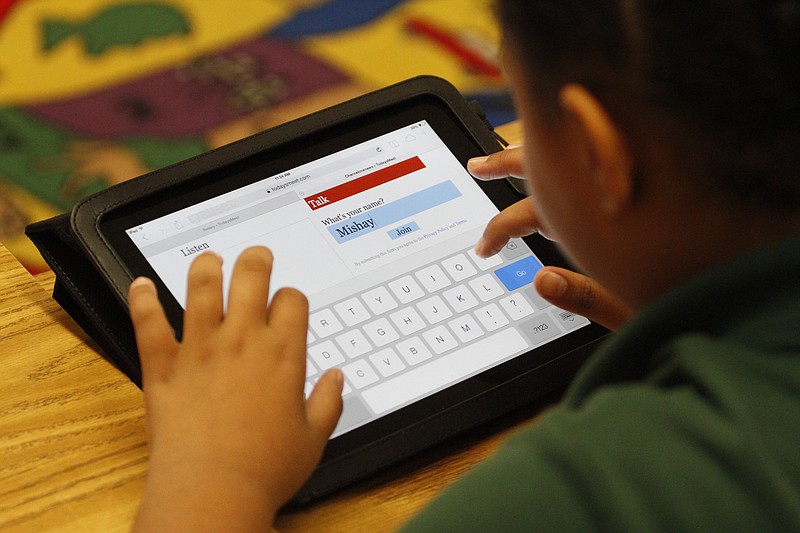 Mishayla Greene, a Woodmore Elementary student in Ashley Frogg's fourth-grade class, works on a new iPad that her class received from the Rotary Club.