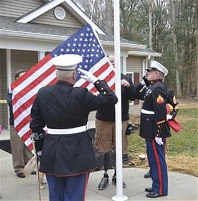 The American flag is raised at the new home of Marine Sgt. Bradley Walker in Dandridge. Walker, who lost his legs in an IED attack in Iraq was provided the home by the non-profit Homes For Our Troops.