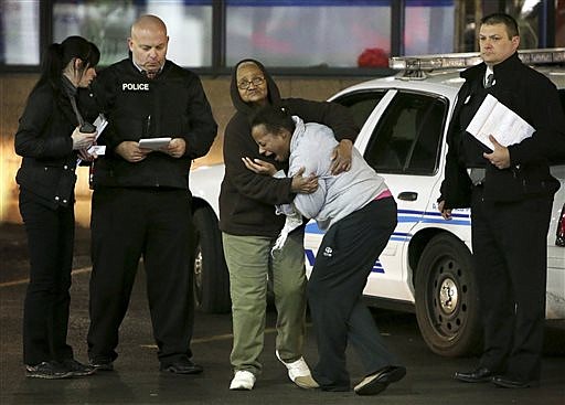 Toni Martin, front center, cries out on Dec. 24, 2014, as she talks to police at the scene where she says her son was fatally shot Tuesday at a gas station in Berkeley, Mo. 