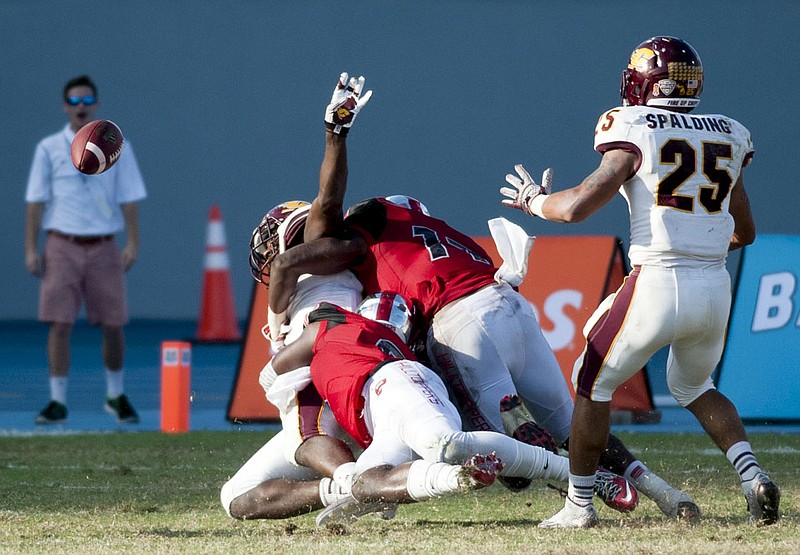 
              Central Michigans tight end Deon Butler laterals the ball while being tackled by Western Kentucky linebacker Dejon Brown  and defensive back Marcus Ward, foreground, during the Bahamas Bowl NCAA college football game, Wednesday, Dec. 24, 2014, in Nassau, Bahamas. (AP Photo/The Daily News, Austin Anthony)
            