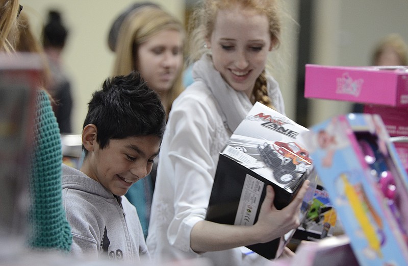 Lydia Fortuna, right helps Fabian Rodriguez pick out toys for her Christmas present. Providence Ministries gave three toys to each child and also served meals to approximately three thousand people at Providence Ministries in Dalton, Ga., on Thursday.