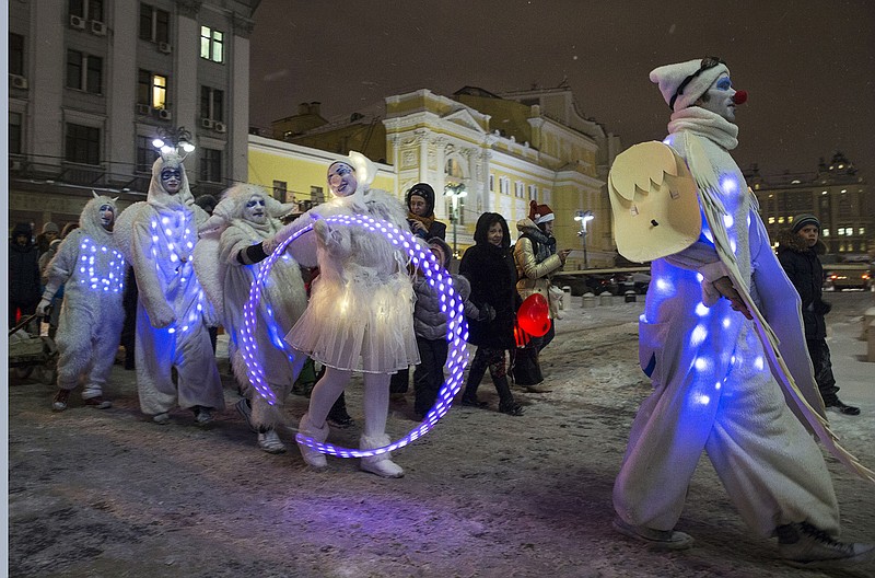 People dressed in illuminated angel costumes parade to mark Christmas Day in central Moscow, Russia, on Thursday, Dec. 25, 2014.