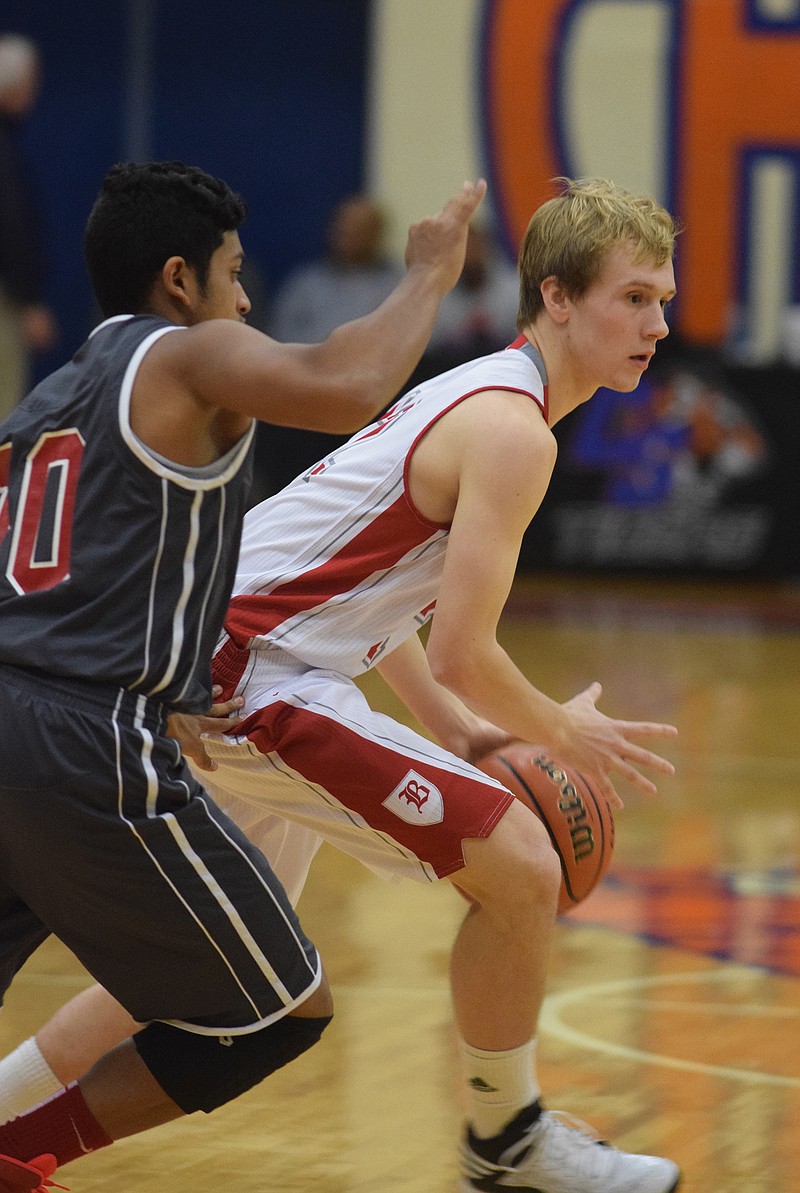 Baylor's Austin Maize (12) looks for an open teammate as Ooltewah's Abel Anchanattu (10) defends.