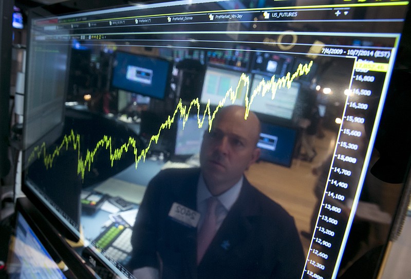 
              FILE - In this July 3, 2014 file photo, specialist Jay Woods is reflected in a screen at his post that shows five years of the Dow Jones industrial average, on the floor of the New York Stock Exchange. The Dow Jones industrial average jumped above 17,000 for the first time that day. The Standard & Poor’s 500 index climbed about 13 percent in 2014, hitting a record high a remarkable 51 times. (AP Photo/Richard Drew, File)
            