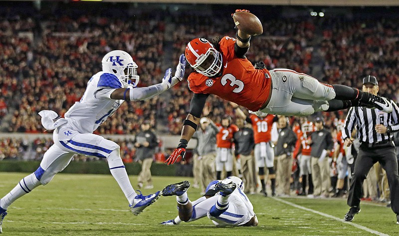 
              FILE - In this Nov. 23, 2013, file photo, Georgia running back Todd Gurley (3) dives into the end zone for a touchdown as Kentucky cornerback Jaleel Hytchye, left, defends in the first half of an NCAA college football game in Athens, Ga. Georgia coach Mark Richt says junior running back Gurley has informed him that he plans to enter the NFL draft. Richt made the announcement after practice Friday, Dec. 26, 2014, for the Belk Bowl. (AP Photo/John Bazemore, File)
            