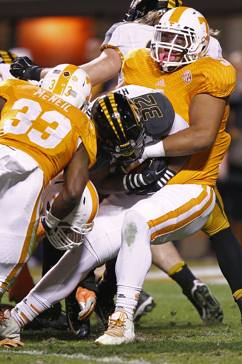 Missouri tailback Russell Hansbrough (32) is tackled by Tennessee defensive end Derek Barnett (9) in the first quarter of a November game in Knoxville.