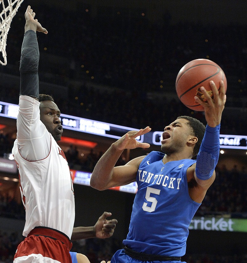 
              Kentucky's Andrew Harrison, right, shoots as Louisville's Mangok Mathiang defends during the first half of an NCAA college basketball game, Saturday Dec. 27, 2014, in Louisville, Ky. (AP Photo/Timothy D. Easley)
            