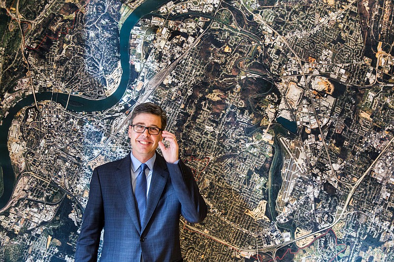 Mayor Andy Berke stands in front of an aerial image of Chattanooga, on the wall of his conference room in this Nov. 17, 2014, photo.