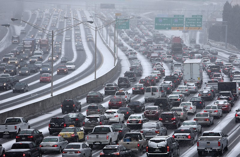 
              FILE-In this Jan. 28, 2014, file photo, traffic inches along the connector of Interstate's 75 and 85 as snow blankets Metro Atlanta as seen from the Pryor Street overpass. The crippling winter storm was one of the top stories of 2014 in Georgia. (AP Photo/The Atlanta Journal-Constitution, Ben Gray, File)
            