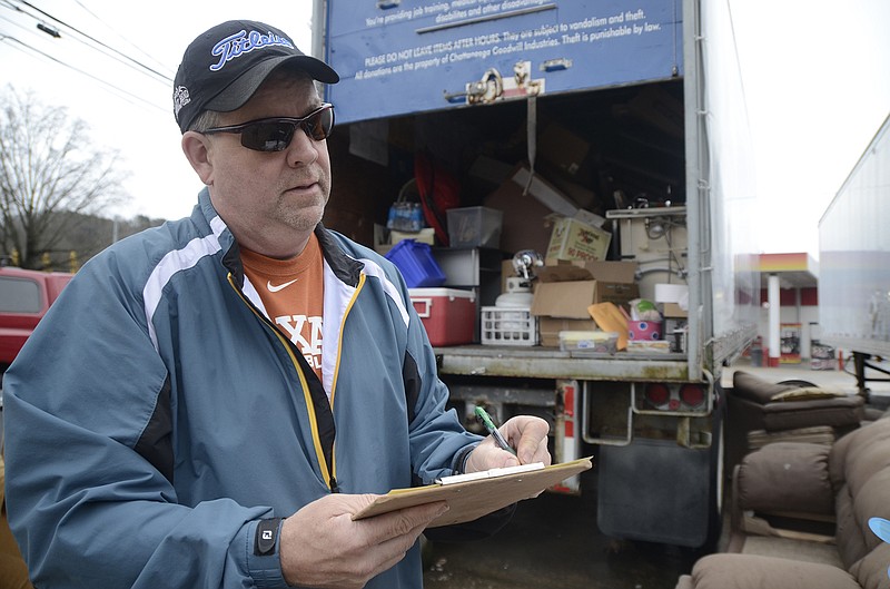 Mike Davis writes down information on a tax write-off form Sunday after dropping off his fourth carload of donations at the Goodwill donation drop-off on Signal Mountain Road. The last week of December marks a surge in the number of year-end, tax-deductible charitable donations.