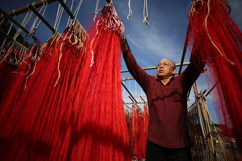 A fisherman takes in the dried fishing nets to catch a local specialty, " Iseebi" or Japanese spiny lobster, Sunday at Touji Port in Shimoda, Shizuoka Prefecture, Japan. Shimoda is located southwest of Tokyo and well known for its hot spring and beaches as well as marine products. (AP Photo/Eugene Hoshiko)