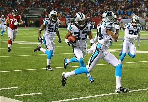 Atlanta Falcons offensive lineman Ryan Schraeder, rear left, pursues Carolina Panthers safety Tre Boston, who runs back an interception of a Matt Ryan pass for a touchdown, during their game Sunday, Dec. 28, 2014, in Atlanta. The Panthers won 34-3.