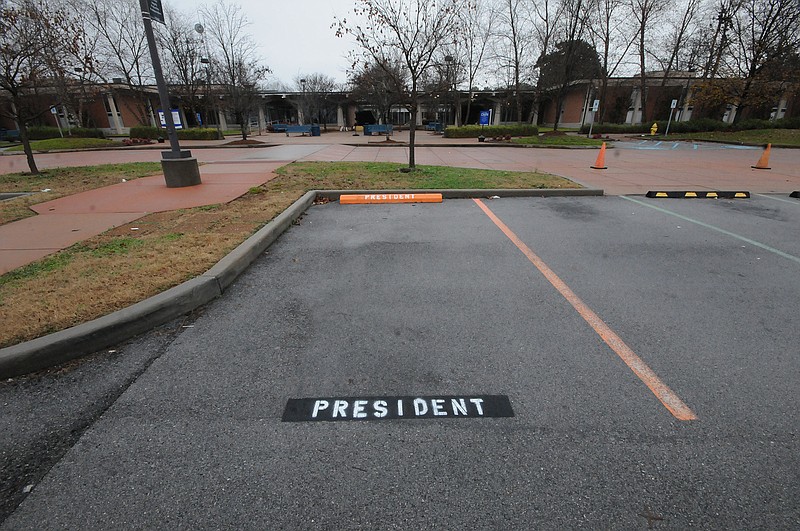 The parking spot for the school president at Chattanooga State is designated by a bright orange tire stop denoting the reservation in white letters.