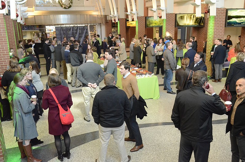 People gather in the lobby of the Imax Theater on Thursday, Nov. 20, 2014 in downtown Chattanooga, Tenn., for a tech startup launch for Text Request. The new company has developed a system that enables customers to send text messages to businesses.
