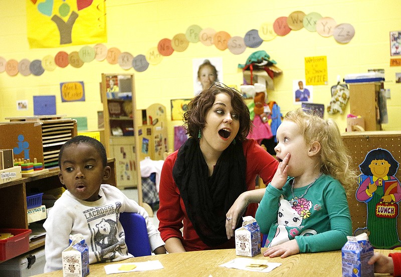 Instructor Cassie Anderson, center, tries to make Zaylee Brown, right, laugh, with Kadrin Grearing on Tuesday, Dec. 23, 2014, at the Chambliss Center for Children in Chattanooga, Tenn. The center began as the Women's Christian Association in 1872 to house children orphaned by the yellow fever epidemic, and it continues today with programs like 24 hour pre-kindergarten services.