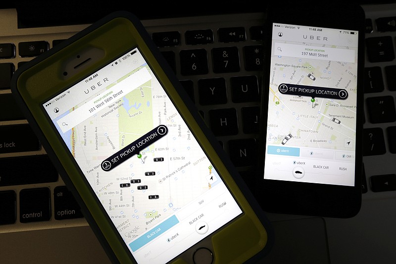 This Friday, Nov. 21, 2014, file photo taken in Newark, N.J., shows smart phones displaying Uber car availability in New York. 