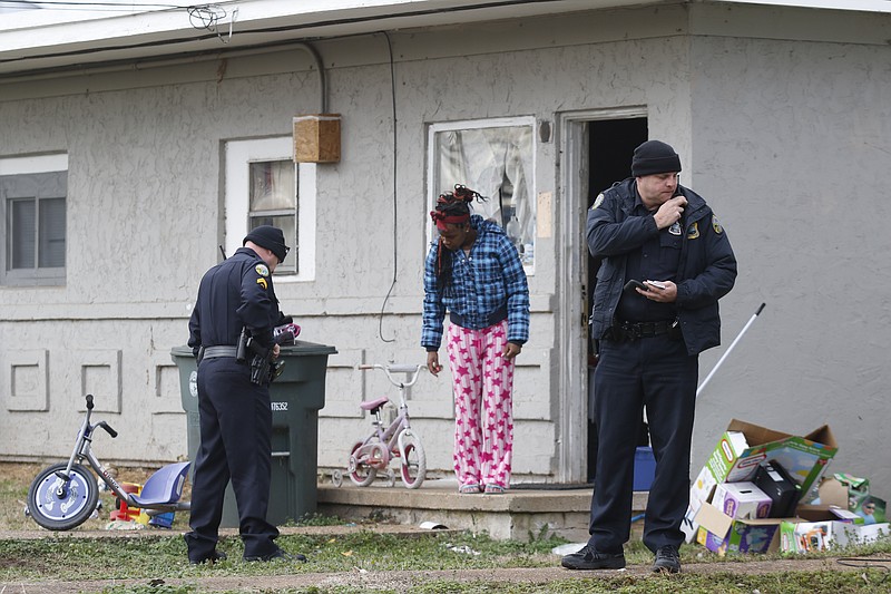 Desiree Witcher, center, stands with police as she prepares to remove belongings from a duplex that was the scene of a fatal shooting early the morning of Thursday, Jan. 1, at 4115 Dorris St. in Chattanooga. Three separate shootings in the morning of New Year's Day left two dead and another in critical condition.