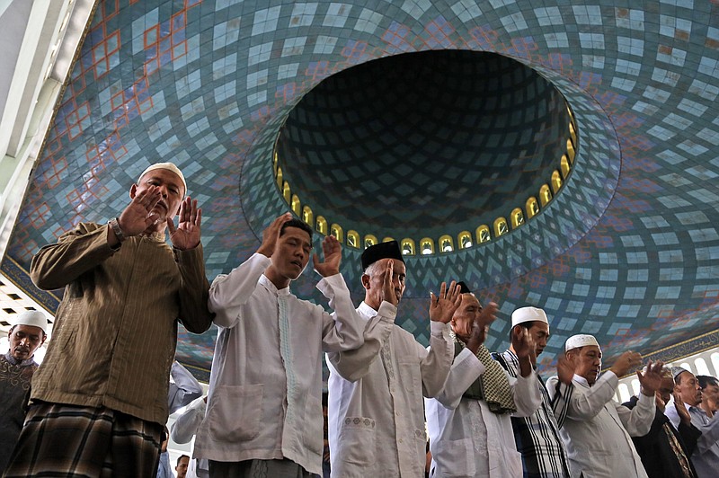 
              Indonesian Muslim men pray during a special prayer for the victims of AirAsia Flight 8501 at Al Akbar Mosque in Surabaya, East Java, Indonesia, Friday, Jan. 2, 2015. More ships arrived Friday with sensitive equipment to hunt for the fuselage of the flight and the more than 145 people still missing since it crashed into the sea five days ago. (AP Photo/Dita Alangkara)
            