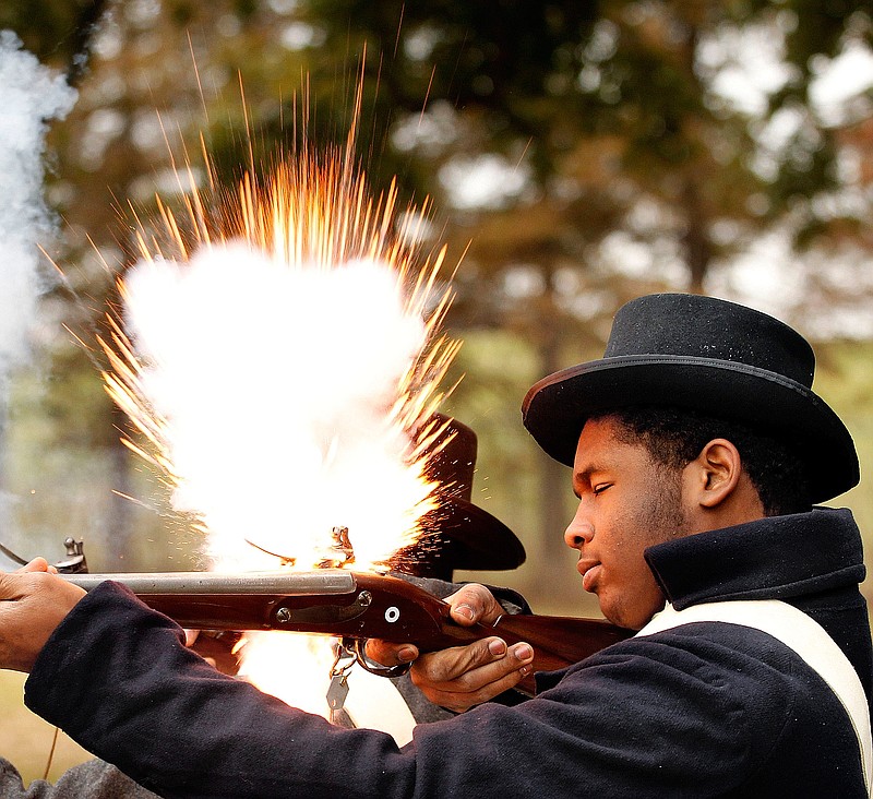 In this Dec. 11, 2011, photo, McDonogh High School student Dyiriell Jenkins fires a blank from a replica Springfield musket during a living history lesson at Chalmette Battlefield in Chalmette, La. Jenkins portrayed a member of the Free People of Color militia, who fought in the Battle of New Orleans. (AP Photo/NOLA.com The Times-Picayune, Eliot Kamenitz) 