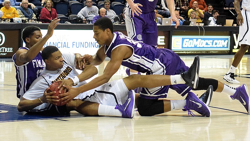 UTC's Chuck Ester (0) fights a couple of Paladins's for a lose ball. The Furman Paladins visited the Chattanooga Mocs at McKenzie Area Saturday night, January 3, 2015.