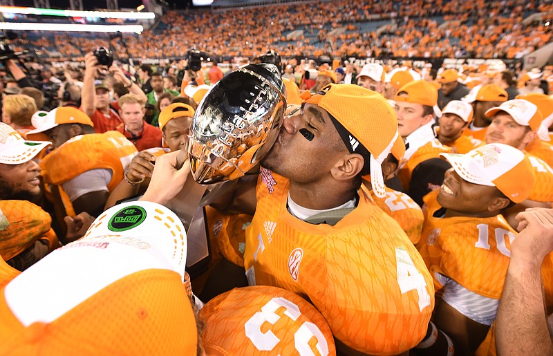 Tennessee's LaTroy Lewis (4) kisses the trophy after the TaxSlayer Bowl NCAA college football game against Iowa on Jan. 2, 2015, in Jacksonville, Fla. Tennessee won 45-28.