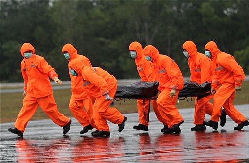 National Search and Rescue Agency personnel carry the body of a victim aboard the ill-fated AirAsia Flight 8501 after being airlifted by a Singapore Navy Super Puma helicopter at the airport in Pangkalan Bun, Indonesia, on Jan. 4, 2015. 