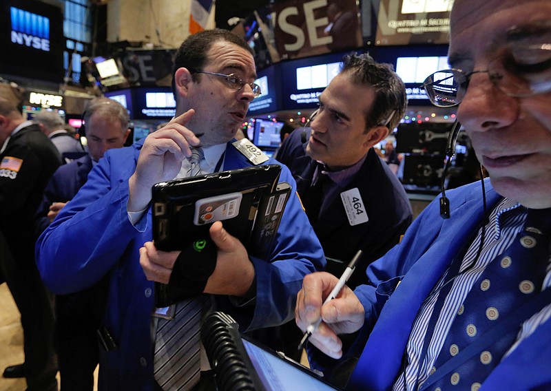 
              Traders Richard Scardino, left, and Gregory Rowe, center, confer on the floor of the New York Stock Exchange Monday, Jan. 5, 2015. US stocks opened lower Monday, led by declines in energy stocks as the price of oil plunged again.  (AP Photo/Richard Drew)
            