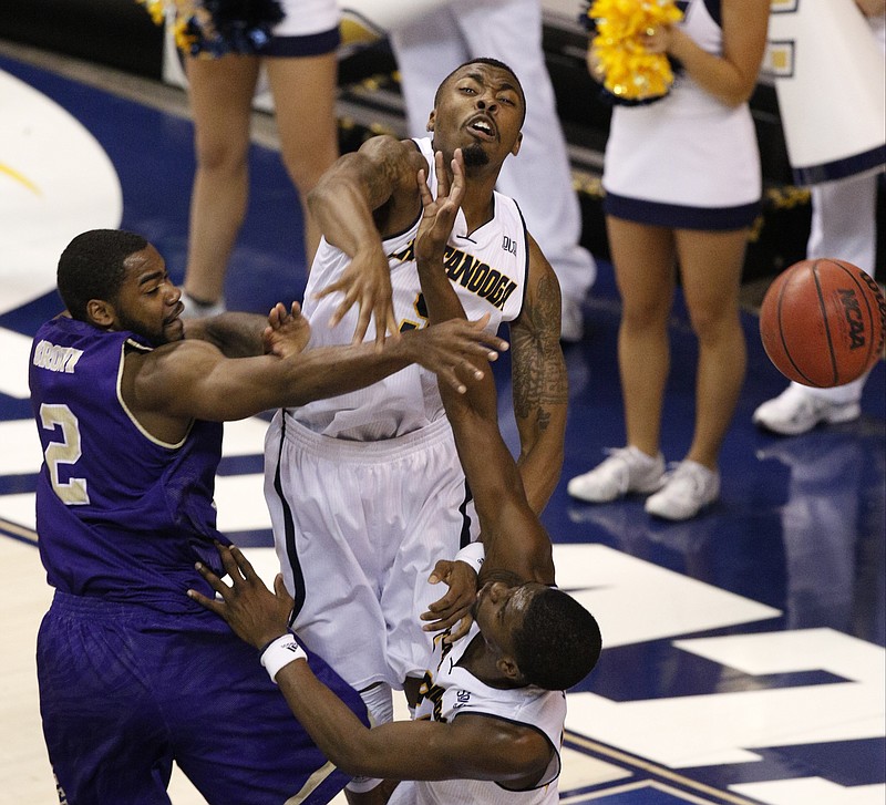 UTC's Justin Tuoyo, center, and Casey Jones, bottom, knock down a shot by Western Carolina's Mike Brown (2) Thursday at McKenzie Arena.
