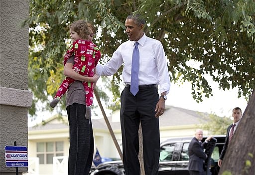 President Barack Obama talks with a woman holding a child on Jan. 8, 2015, in Phoenix.