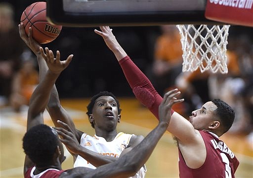 Alabama forward Jimmie Taylor (10) and forward Michael Kessens (3), from left, defend as Tennessee guard Josh Richardson (1), center, shoots a jumper during their game at Thompson-Boling Arena in Knoxville on Saturday, Jan. 10, 2015. Tennessee lost 56-38.