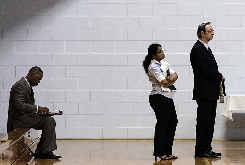 Job seekers wait in a line at a job fair in this file photo