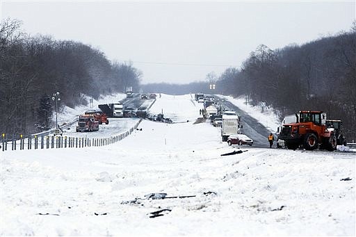 Road crews work to clear wrecked vehicles and debris along Interstate 94, on Jan. 10, 0215, the day after a series of crashes closed the highway between mile markers 88 and 92 in eastern Kalamazoo County, near Galesburg, Mich. 