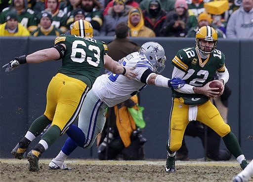 Green Bay Packers quarterback Aaron Rodgers (12) escapes the pass rush of Dallas Cowboys defensive tackle Nick Hayden (96) during their game, Sunday, Jan. 11, 2015, at Lambeau Field in Green Bay, Wis. The Packers won 26-21. 