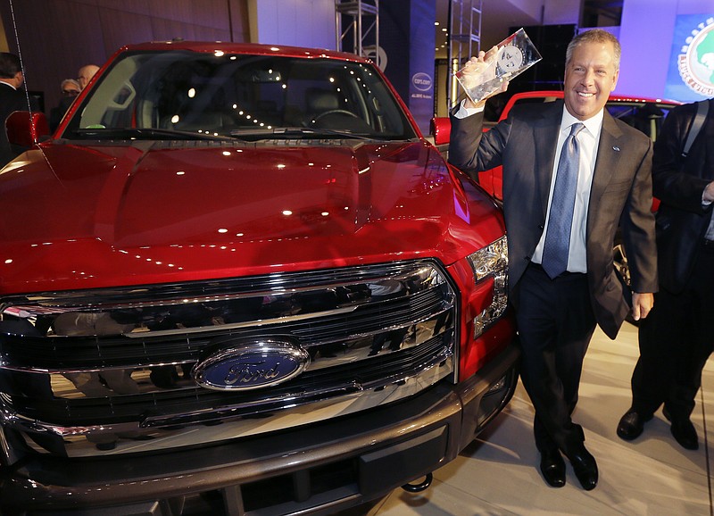 
              Joe Hinrichs, Ford executive vice president and president, the Americas, poses with the Ford F-150 truck after winning the North American Truck of the Year during the North American International Auto Show, Monday, Jan. 12, 2015, in Detroit. (AP Photo/Carlos Osorio)
            