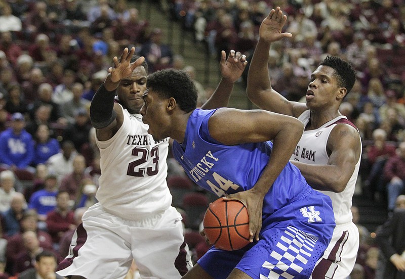 Kentucky's Dakari Johnson (44) takes a shot over Texas A&M's Danuel House (23) and Tavario Miller during the first half of an NCAA college basketball game Saturday, Jan. 10, 2015, in College Station, Texas.