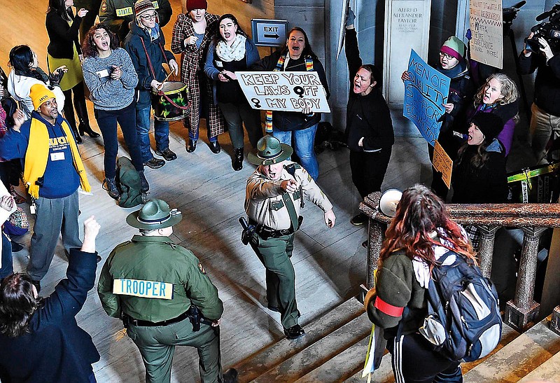 A Tennessee Highway Patrol trooper issues orders to a protester at the State Capitol during a rally Tuesday, Jan. 13, 2015, in Nashville, Tenn. The protesters rallied at the opening of the second session of the 109th General Assembly in response to the ratification of Amendment One in November, which added language to the Tennessee Constitution giving legislators the power to place restrictions on abortions.