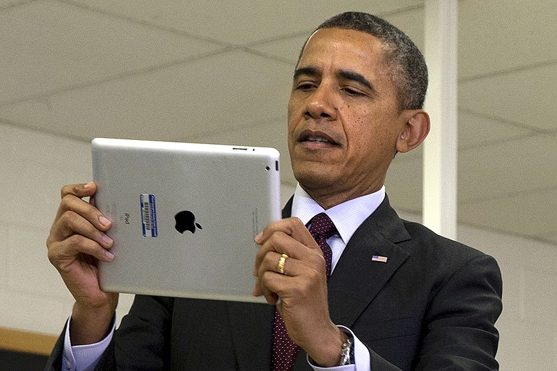 President Barack Obama looks at a classroom iPad in a seventh grade classroom Tuesday, Feb. 4, 2014, at Buck Lodge Middle School in Adelphi, Md., before speaking about his ConnetED goal of connecting 99 percent of students to next generation of students to next generation broadband and wireless technology within five years,