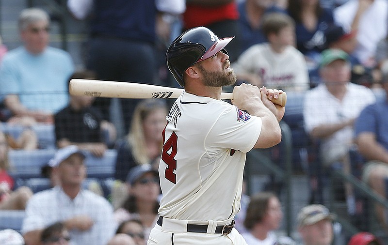 Atlanta Braves catcher Evan Gattis (24) follows through on a solo-home run in the second inning of a baseball game against the Colorado Rockies Sunday, May 25, 2014, in Atlanta.