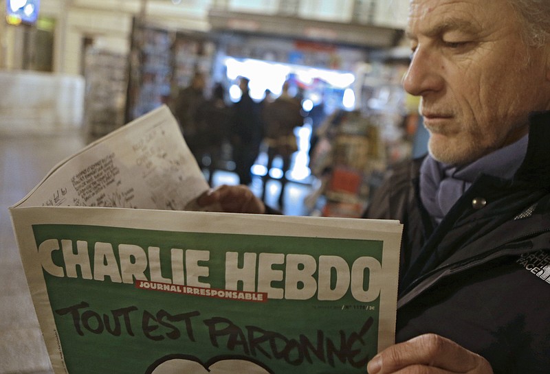 
              Jean Paul Bierlein reads the latest issue of Charlie Hebdo outside a newsstand in Nice, southeastern France, Wednesday, Jan. 14, 2015. In an emotional act of defiance, Charlie Hebdo resurrected its irreverent and often provocative newspaper, featuring a caricature of the Prophet Muhammad on the cover that drew immediate criticism and threats of more violence. The black letters on the front page read: "All is forgiven." (AP Photo/Lionel Cironneau)
            