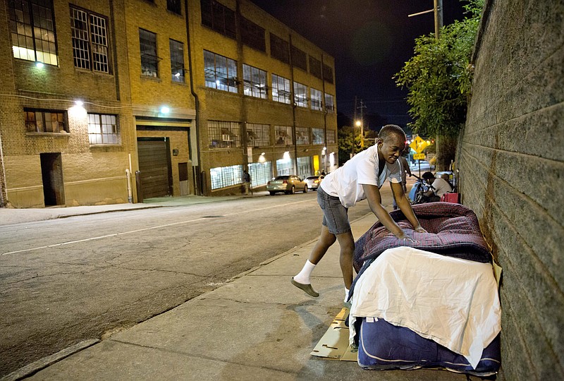 
              In this Oct. 2, 2014 photo, Wanda Walker makes her bed as she prepares to sleep on the street across from the Metro Task Force for the Homeless, the city's largest homeless shelter, in Atlanta. "I like the outdoors," says Walker when asked why she doesn't sleep inside the shelter instead. "I prefer my freedom." Atlanta city officials say they're preparing to conduct a count of the city's homeless population. City officials said in a statement the Homeless Point-in-Time Count will be conducted between Jan. 22 and 24, 2015. Officials say while counting the number of people living on the streets, volunteers will also administer surveys to get a better idea of the needs of the city's homeless population.  (AP Photo/David Goldman)
            