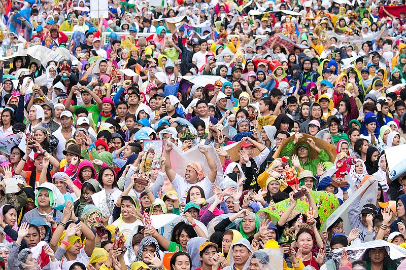 
              Filipinos raise their image of the Santo Nino (Holy Child) during the final papal mass of Pope Francis at Quirino Grandstand in Manila, Philippines, Sunday, Jan. 18, 2015. Millions filled Manila's main park and surrounding areas for Pope Francis' final Mass in the Philippines on Sunday, braving a steady rain to hear the pontiff's message of hope and consolation for the Southeast Asian country's most downtrodden and destitute. (AP Photo/Ron Soliman)
            