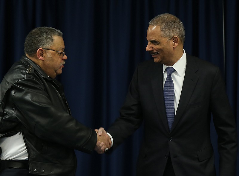 U.S. Attorney General Eric Holder, right, greets Philadelphia Police Commissioner Charles A. Ramsey, left, before they participate in the Building Communities of Trust roundtable discussion in Philadelphia on Jan. 15, 2015. 