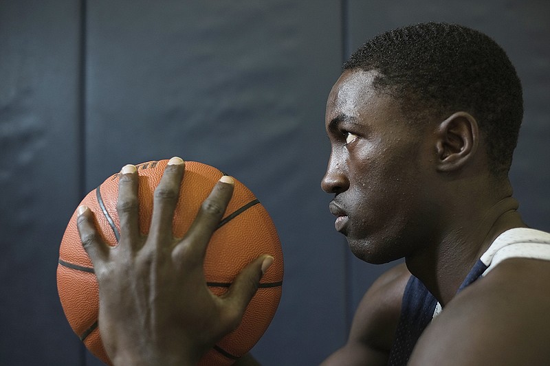 Hamilton Heights basketball player Silas Adheke holds a basketball at Hamilton Heights Christian Academy. 