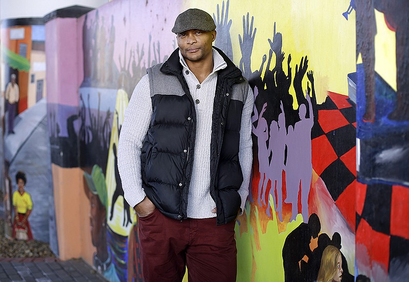 Former Tennessee Titans running back Eddie George stands by a mural at an urban improvement project designed and constructed by Edge, his landscape design and development company in Nashville.