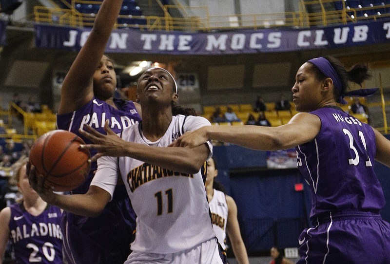UTC's Ka'Vonne Towns (11) breaks between Furman's Brittany Hodges (31) and Holli Wilkins during the Mocs' SoCon  game against the Furman Paladins on Saturday at McKenzie Arena in Chattanooga. UTC won, 67-45.
